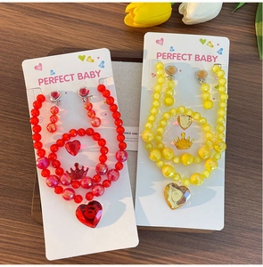 Detailed view of handmade beaded jewelry set for girls with heart and crown pendants