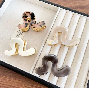 Set of four S-shaped acetate hair claws in leopard, pearl, and grey marble finishes