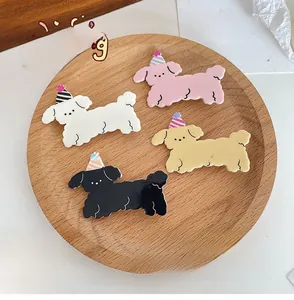 Dettaglio di quattro graziose mollette per capelli a forma di cane su vassoio di legno