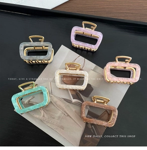 Set of six rectangular acetate hair claws in marble textures and pastel colors on black tray