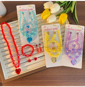 Detailed close-up of colorful beaded heart jewelry sets for kids on a jewelry tray
