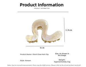 Macro view of wave-shaped pearlescent hair claw with gold metal teeth and 6cm size label