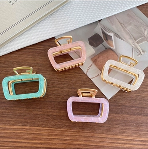 Close-up of four marble acetate square hair claws in mint, pink, cream and lilac