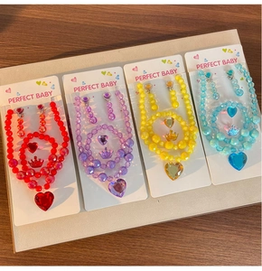 Detail view of colorful bead necklaces and bracelets set with heart and crown pendants