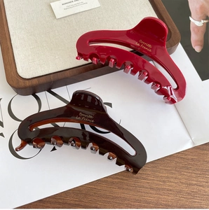 Detail of elegant French acetate hair claw clips in tortoise and burgundy colors