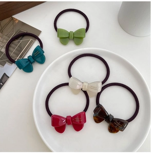 Detailed set of five acetate bow hair ties in green, cream, burgundy and tortoise shell