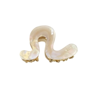 Minimalist pearl white acetate wave hair claw clip with gold metal teeth on white background