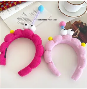 Detail of plush cartoon headband with stretchable spring balls and large funny eyes