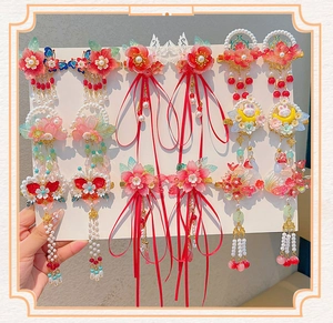 Detailed close-up of Hanfu hair clips with floral patterns, pearls, and long silk tassels