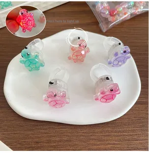Gros plan de bagues tortue colorées avec effet LED en plastique transparent à paillettes