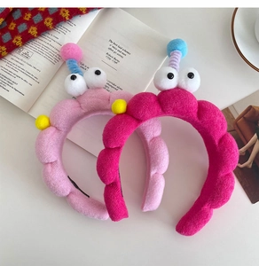 Detail showing plush headbands with large eyes on an open book for a cozy home atmosphere
