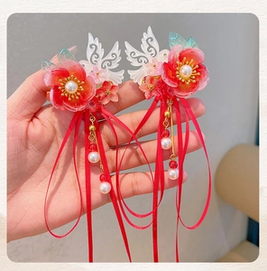 Detailed shot of traditional Chinese hair clips with red flowers and long ribbon tassels