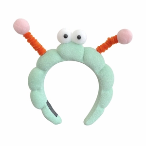 Cute mint green plush headband with big eyes and orange spiral antennas for washing face