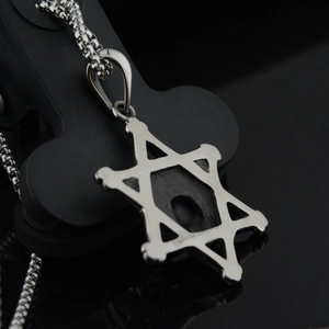 Collier avec pendentif étoile à six branches en acier inoxydable sur support noir pur