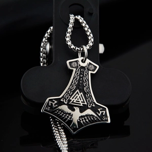Dettaglio del ciondolo Mjölnir con simboli Valknut e incisioni di rune nordiche