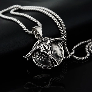 Détail d'un pendentif tête de taureau vintage avec texture soleil sur chaîne en acier