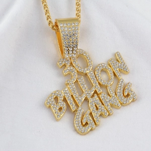 Dettaglio del ciondolo hip hop 300 BILLION GANG placcato oro con strass e catena a fune