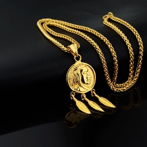 Detailed shot of gold Indian coin necklace with feather charms on black leather surface