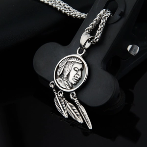 Macro detail of Indian coin pendant with feathers and vintage titanium steel chain