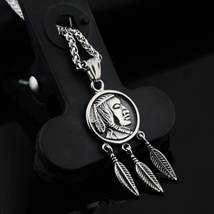 Macro view of titanium steel necklace with native eagle feather and coin pendants