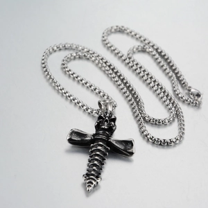 Vue détaillée du pendentif croix crâne gothique en acier argenté vieilli et chaîne à billes