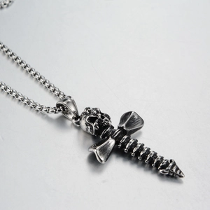 Vue détaillée d'un pendentif croix tête de mort gothique sur une chaîne en acier inoxydable