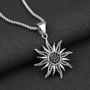 Gros plan du pendentif rayon de soleil avec strass noirs sur une chaîne à billes argentée