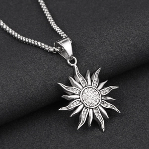Gros plan du pendentif soleil vintage avec strass étincelants sur une chaîne à billes