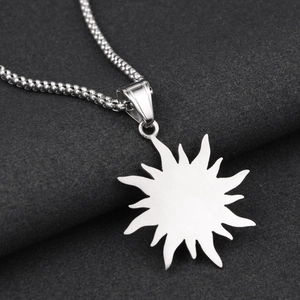 Détail macro du collier pendentif soleil argenté avec chaîne maille box style urbain