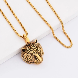 Detailed view of the gold tiger head pendant with an intricate embossed pattern