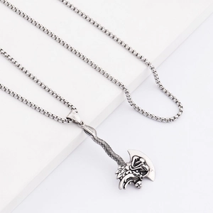 Macro detail of vintage silver dragon axe pendant with stainless steel box chain