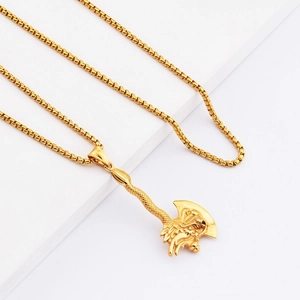 Detail of golden dragon axe pendant with textured handle and intricate relief on box chain