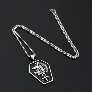 Ancient Egyptian Anubis coffin pendant necklace in polished stainless steel on black surface