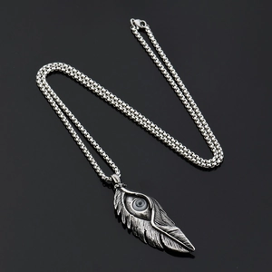 Collier hip hop en acier titane avec pendentif plume gothique et détail d'œil réaliste