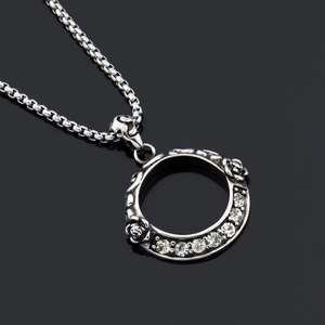 Dettaglio macro del ciondolo a ghirlanda di rose d'argento con diamanti e catena a maglia
