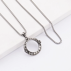 Dettaglio della collana in acciaio al titanio con anello cavo, rosa 3D e inserti in zircone