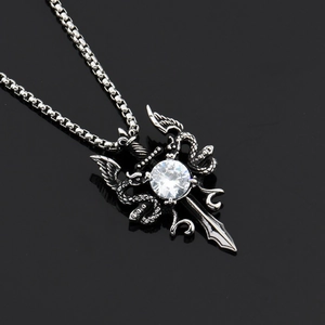 Detailed view of gothic sword pendant with large round zircon and dragon wing motifs