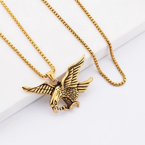 Hip hop style gold falcon pendant necklace with detailed eagle wings on white stand