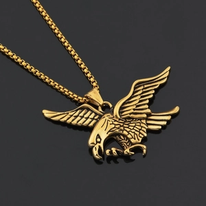 Detail of a golden eagle pendant with intricate feather texture on a box chain