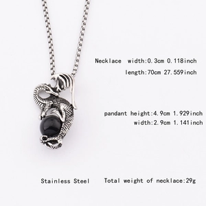 Vue détaillée du pendentif dragon hip-hop tenant une perle noire sur chaîne en acier inox