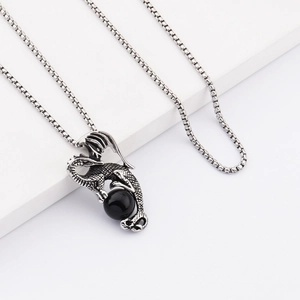 Collier hip hop en acier titane avec pendentif dragon et perle noire sur socle blanc