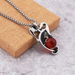 Détail d'un pendentif dragon hip-hop avec perle rouge sur une chaîne argentée