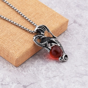 Détail du collier de dragon gothique avec pierre rouge sur boîte cadeau orange