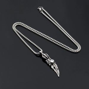Collana hip hop in acciaio al titanio con piuma e zircone bianco su sfondo nero lucido