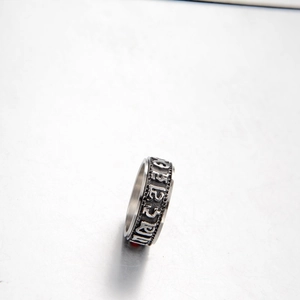Détail macro d'une bague rotative en acier inoxydable avec runes religieuses vintage