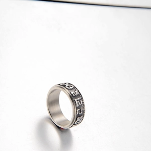 Vue macro d'une bague large vintage en acier inoxydable avec symboles gravés