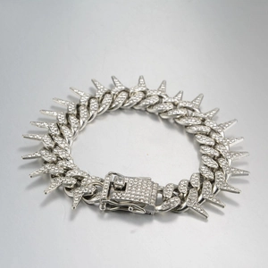 Macro shot of micro-pave zircon thorn link bracelet with iced-out spiked Cuban chain detail