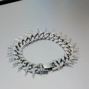 Macro detail of silver hip-hop thorn Cuban bracelet with colorful pavé rhinestones