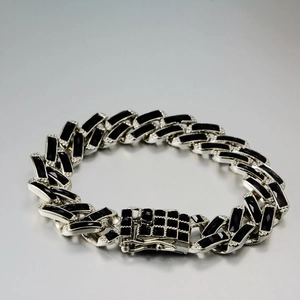 Macro detail of silver Cuban chain bracelet featuring black zircon stones and micro pavé