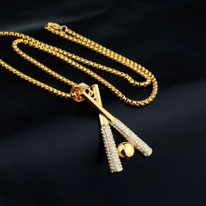 Nahaufnahme eines goldenen Baseballschläger-Anhängers mit Kristallen an einer Box-Kette